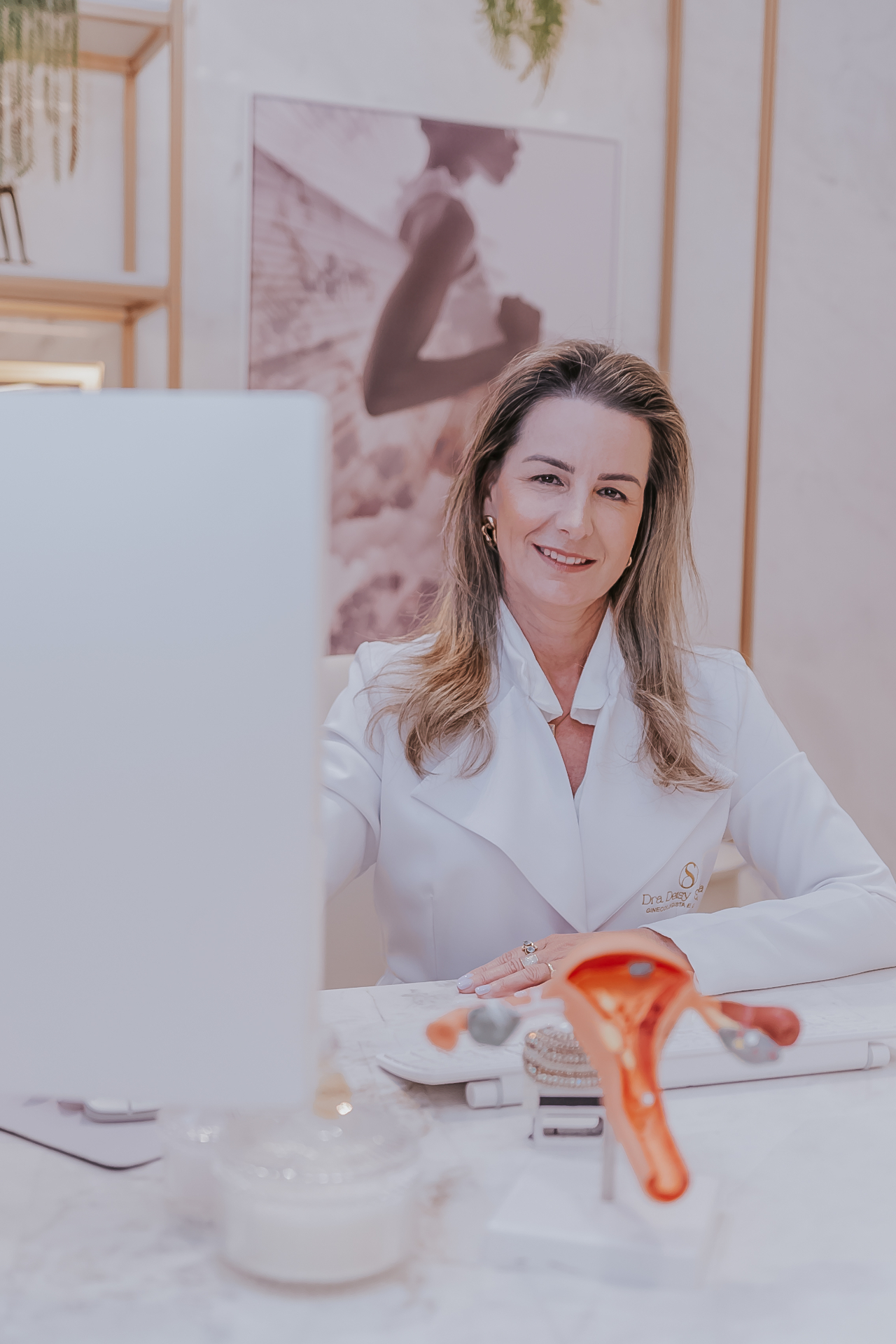 Dra. Deisy Shibata no consultório com modelo anatômico do útero
